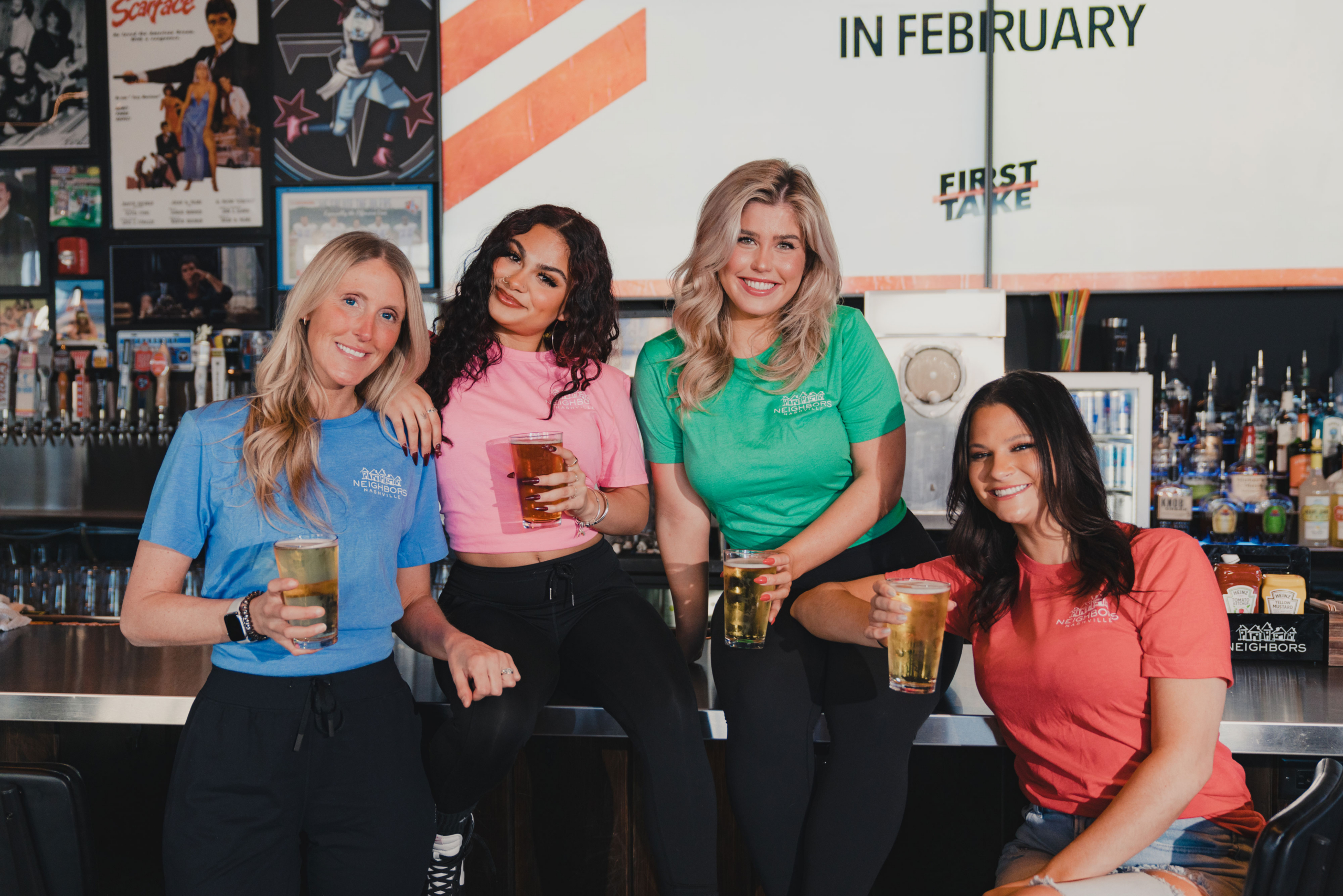 four neighbors models posing with branded t-shirts holding drinks